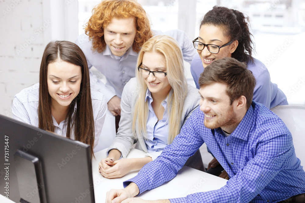 smiling business team looking at computer monitor smiling business team looking at computer monitor