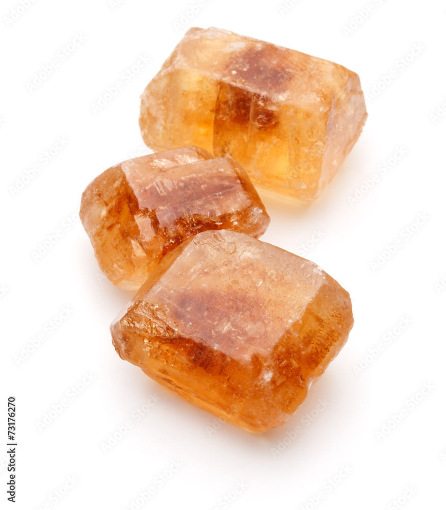 Brown caramelized lump cane sugar cube isolated on white backgro Brown caramelized lump cane sugar cube isolated on white backgro