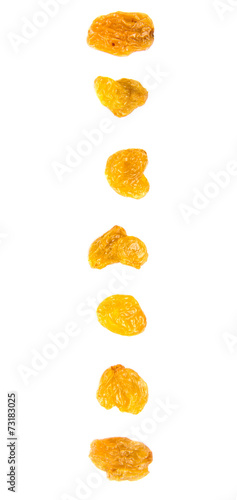 Golden colored dried raisin over white background
