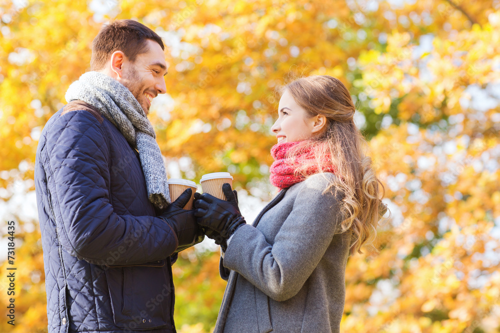 smiling couple with coffee cups in autumn park smiling couple with coffee cups in autumn park