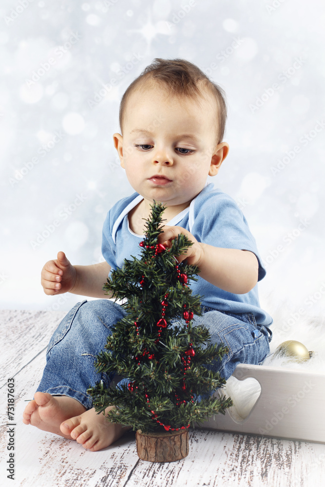 Little baby boy decorating christmas tree