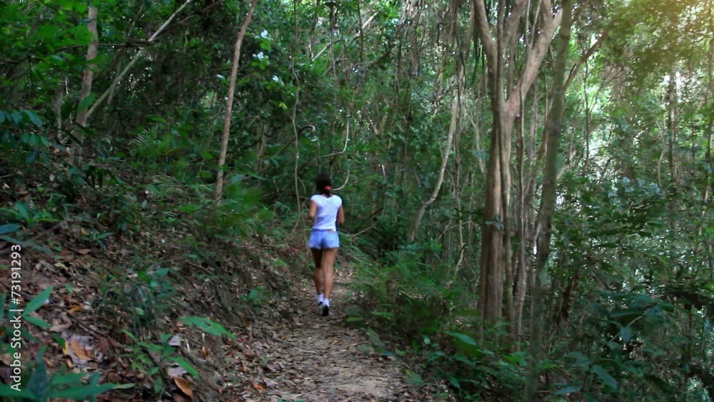 Young fitness woman running in jungle forest on Koh Samui. HD.