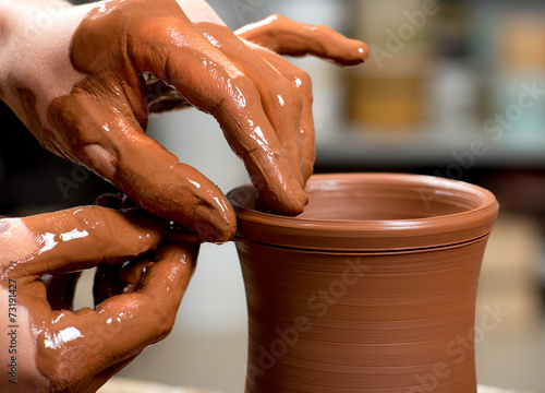 hands of a potter, creating an earthen jar