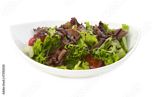 Salad with meat in white bowl isolated