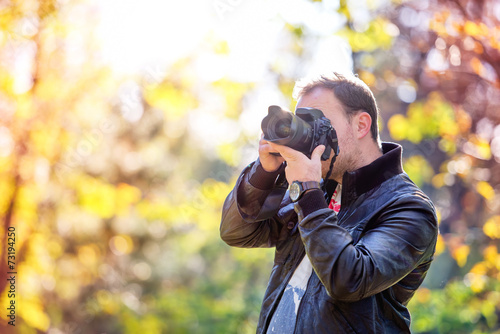 photographer with professional digital camera taking pictures