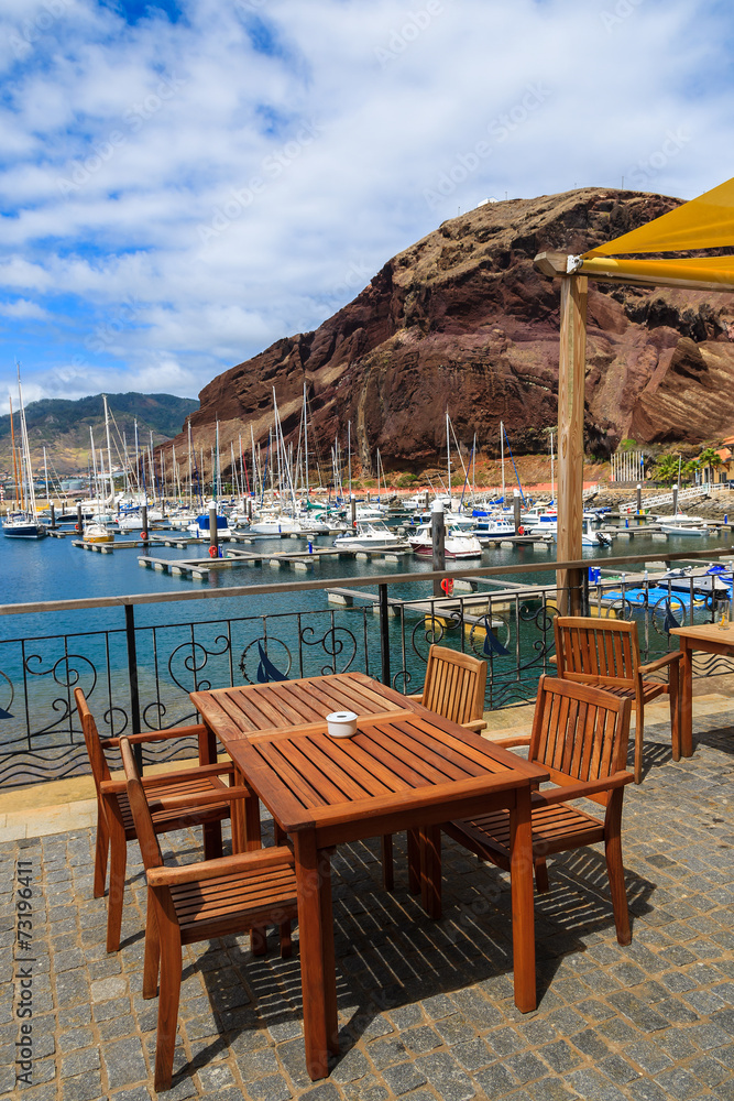 Chairs and table in harbour with yacht boats, Madeira island
