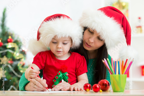 Child girl and mother writi...