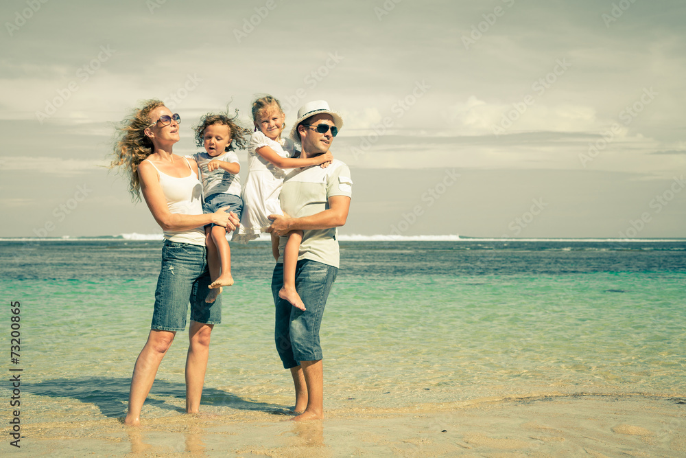 Happy family standing on the beach at the day time