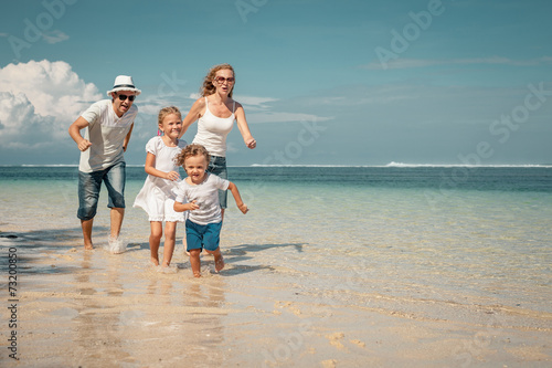 Happy family running on the beach at the day time
