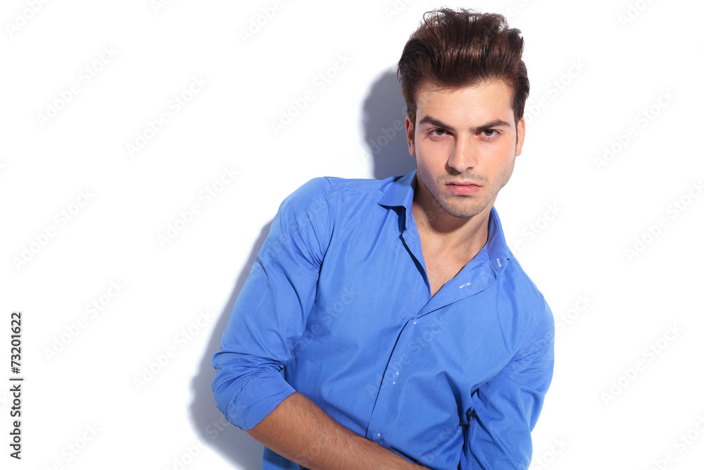 handsome young man leaning on a white wall handsome young man leaning on a white wall