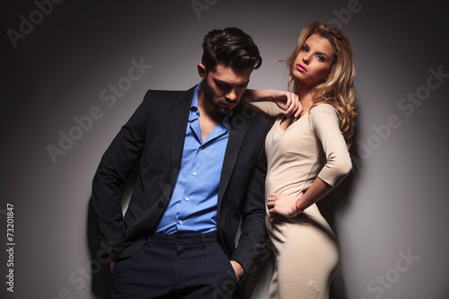 man looking down while his girlfriend is leaning on him