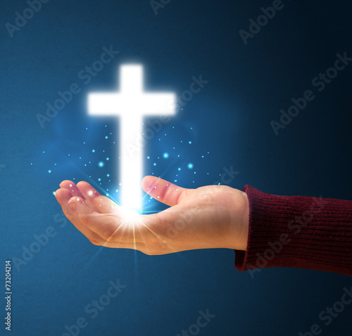 Glowing cross in the hand of a woman