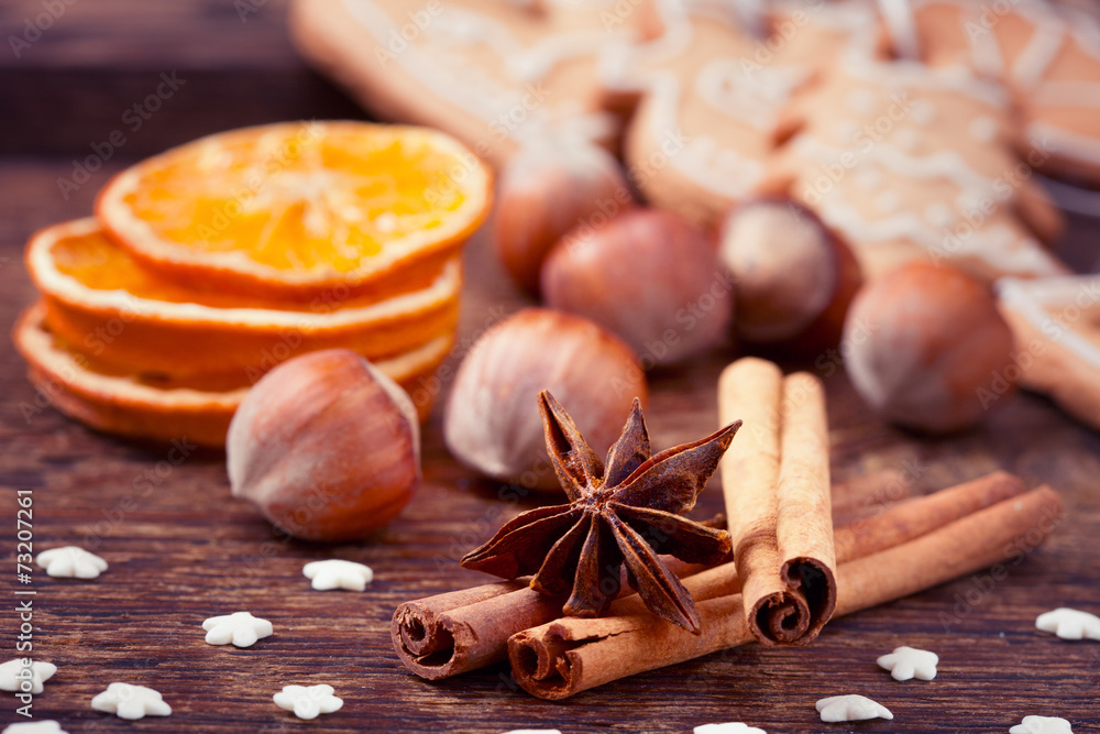 Gingerbread cookies and spices over wooden background.