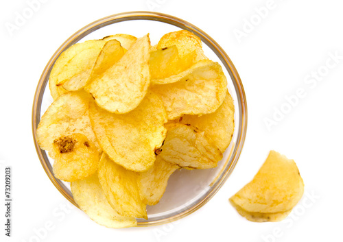 Bowl with potato chips on white background top view