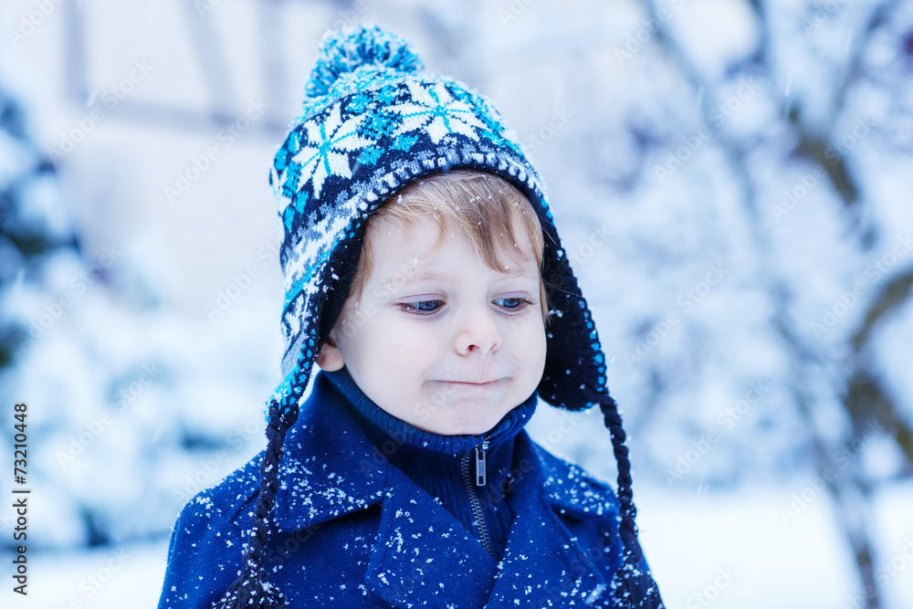 Portrait of little child in winter clothes with falling snow Portrait of little child in winter clothes with falling snow