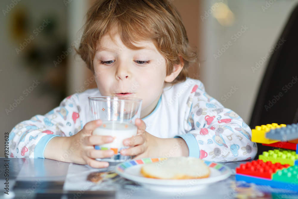 Little kid boy drinking milk and playing with construction block Little kid boy drinking milk and playing with construction block
