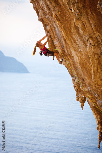 Female rock climber on cliff, Kalymnos Island, Greece