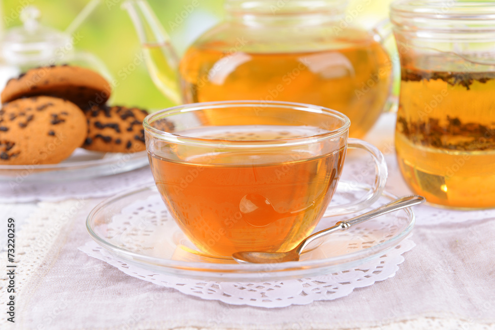 Teapot and cups of tea on table on bright background Teapot and cups of tea on table on bright background