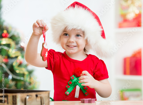 kid girl in Santa hat holdi...
