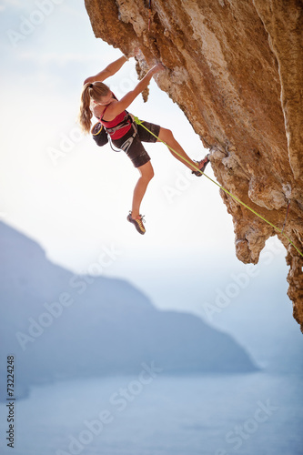 Female rock climber on cliff, Kalymnos Island, Greece