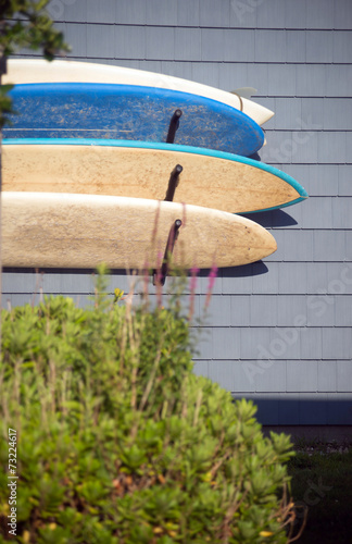 worn surfboards hanging from trailer house Montauk New York USA photo