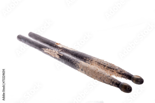 photo of closeup of used and worn-out black drum sticks for drum