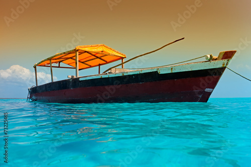 Wooden boat on the clear turquoise water of Zanzibar island
