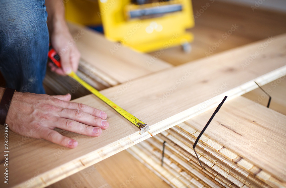 Handyman measuring wooden floor Handyman measuring wooden floor