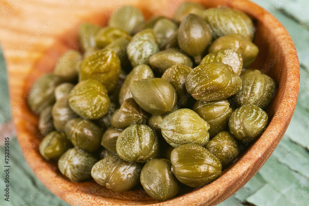 capers in a wooden spoon capers in a wooden spoon