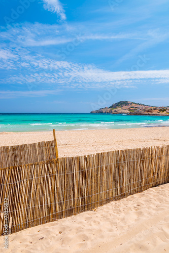 Wind fence on idyllic sand beach of Cala Agulla  Majorca  Spain