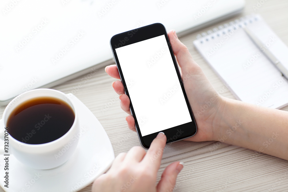 Women hands holding the phone with isolated screen above desk Women hands holding the phone with isolated screen above desk