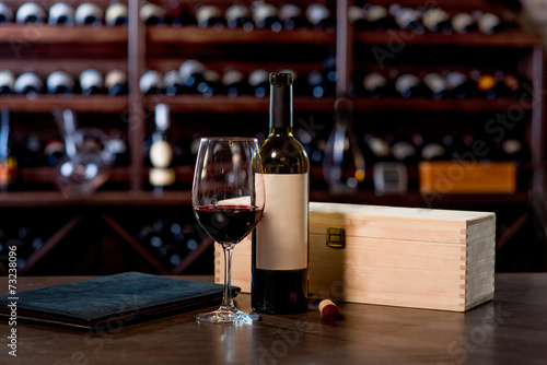 Wine bottle with glass and menu on the table photo