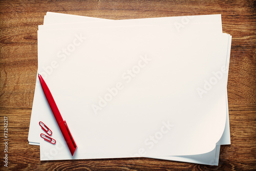 Pen and paperclips on blank sheets of paper