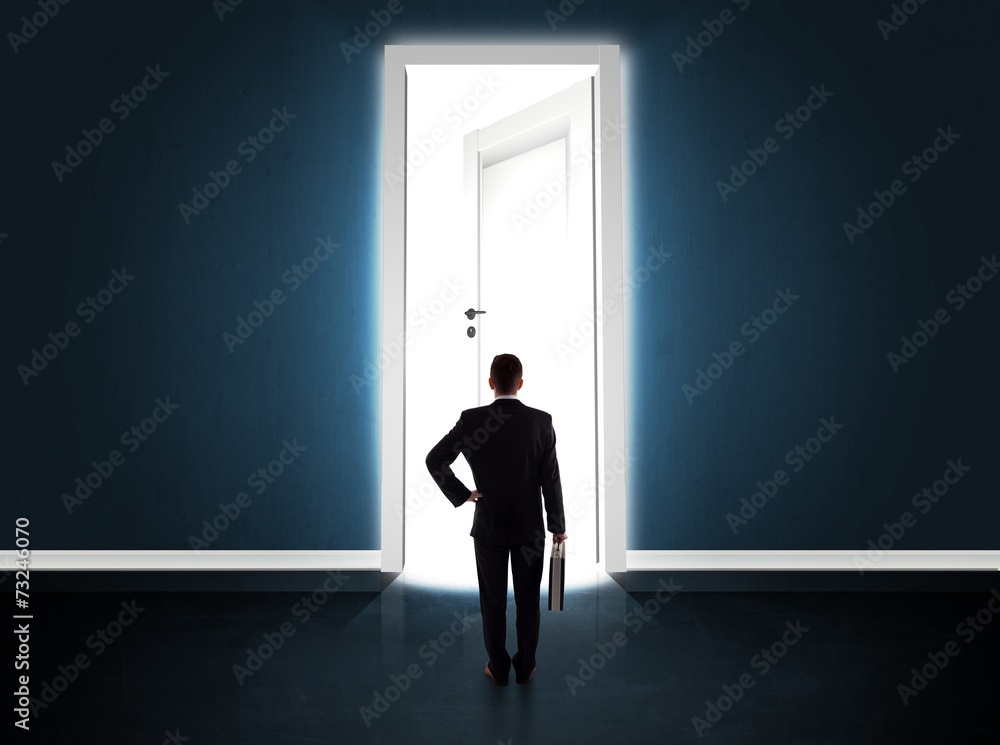 Fototapeta premium Business man looking at big bright opened door