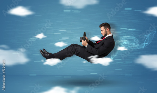 Funny racedriver young man driving between clouds concept