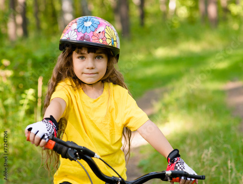 little girl on bike looking at camera and smiling