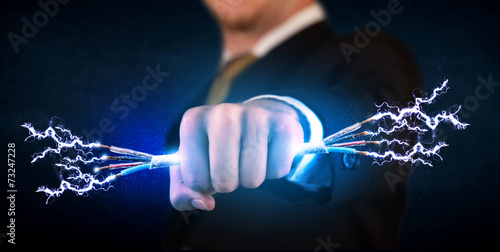 Business person holding electrical powered wires