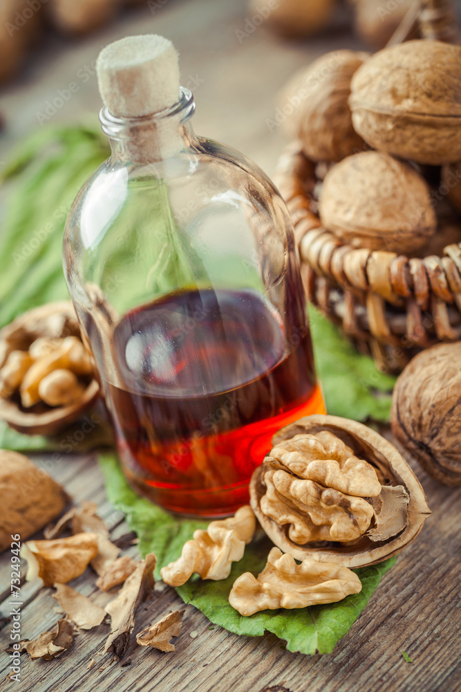 Walnuts, bottle of tincture or oil and wicker basket with nuts o Walnuts, bottle of tincture or oil and wicker basket with nuts o