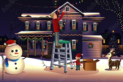Father son putting up lights around the house for Christmas
