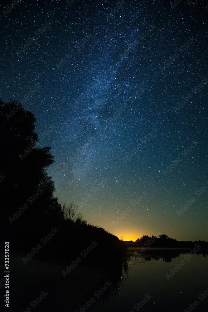 Fototapeta premium Smooth surface of the lake on a background the starry sky