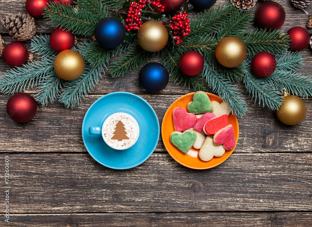 Hot cappuccino with christmas tree shape on a wooden table near Hot cappuccino with christmas tree shape on a wooden table near