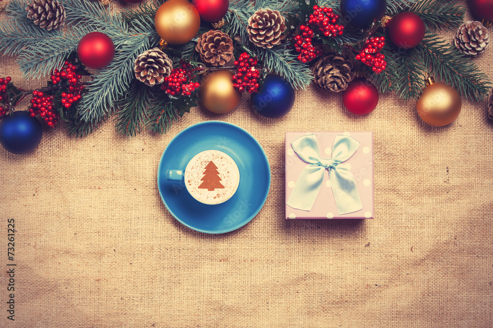 Hot cappuccino with christmas tree shape on a table near pine br Hot cappuccino with christmas tree shape on a table near pine br