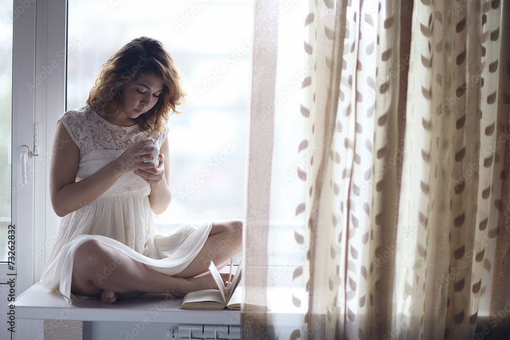 Pregnant girl sitting on the windowsill