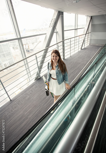 young woman with handbag walking at modern airport terminal