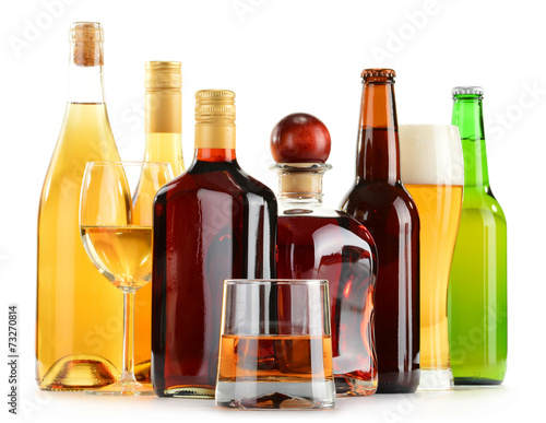 Bottles and glasses of assorted alcoholic beverages over white