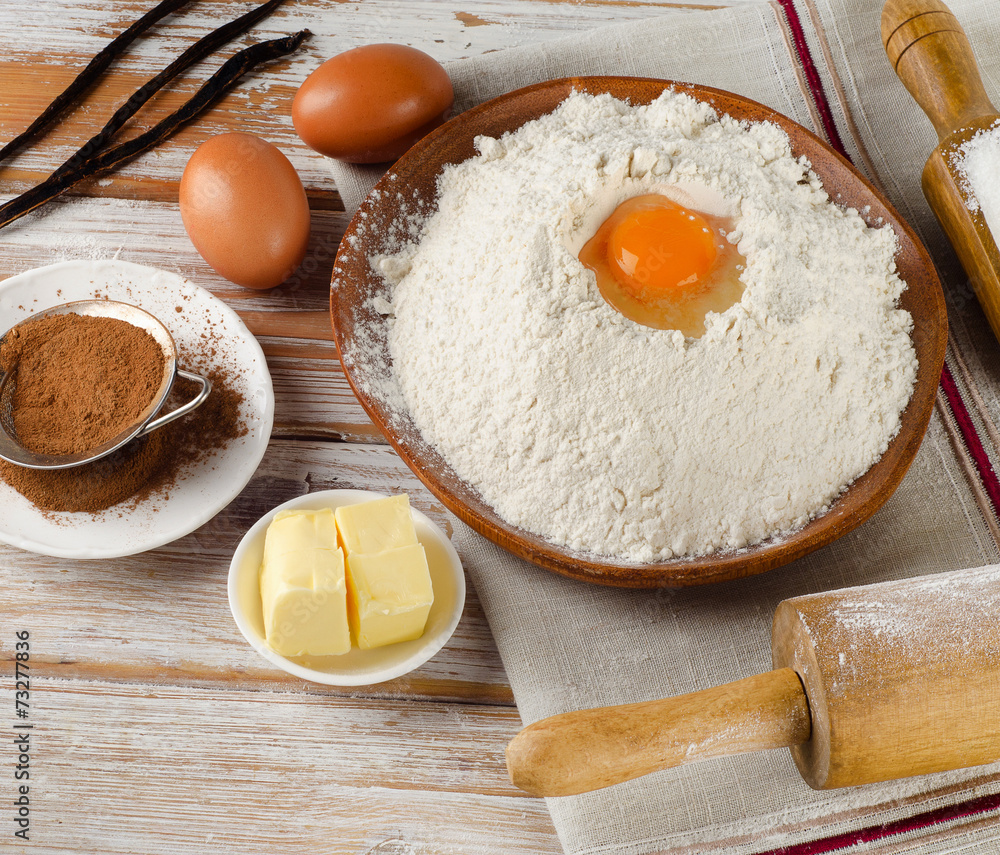 Eggs, flour, sugar, butter on white a white wooden table Eggs, flour, sugar, butter on white a white wooden table
