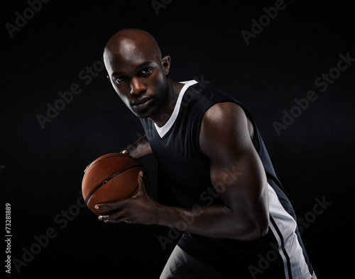 Fit young male athlete playing basketball