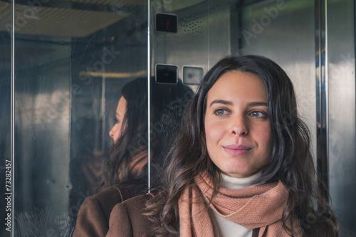 Portrait of a beautiful young woman inside a lift © tinx