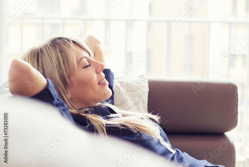 Relaxed young woman lying on couch photo