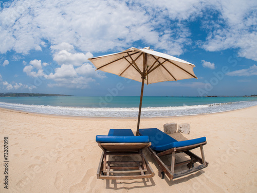 Relaxing couch chairs with parasol on white sandy Beach © Netfalls